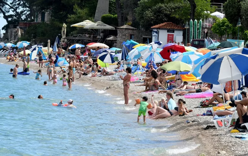 Families pack the beach as they sunbathe and swim in Moscenicka draga, near Croatia's western town of Rijeka, on Adriatic sea , on July 10, 2020. - The number of tourists in Croatia has increased, but at the same time the number of people suffering from the novel coronavirus, COVID-19,  is growing. (Photo by DENIS LOVROVIC / AFP)