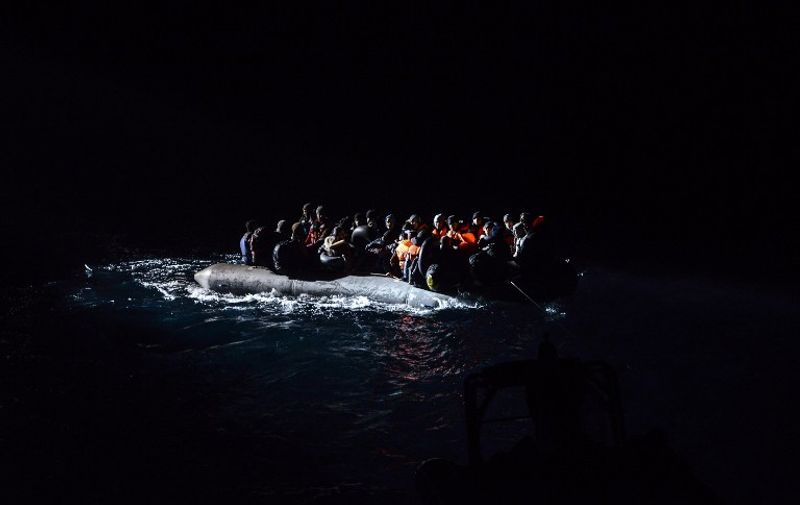 Syrian migrants aboard an inflatable dinghy are about to be rescued while attempting to reach the Greek Island Chios, on the Agean Sea near Izmir in the night of December 9 to December 10, 2015. 
More than 886,000 migrants have arrived in Europe by sea so far this year, according to the latest UN figures. / AFP / BULENT KILIC