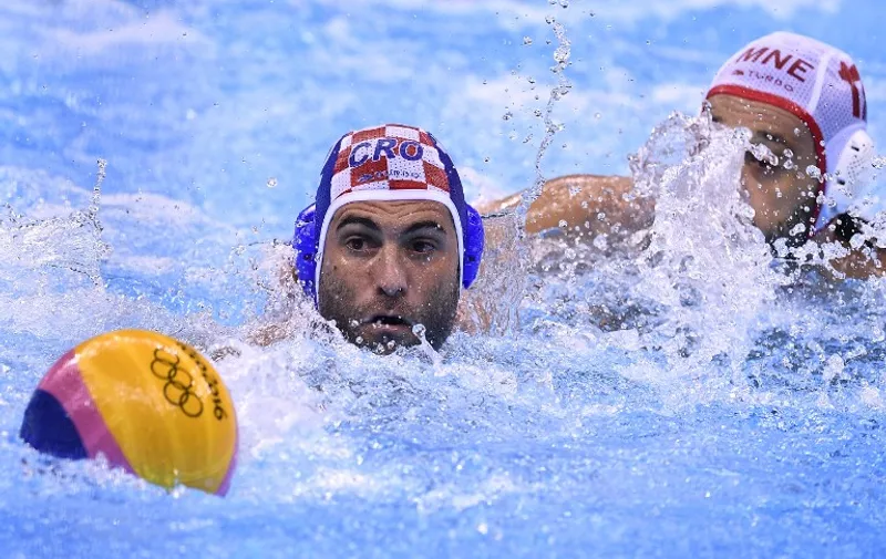 Croatia's Marko Macan (L) vies with Montenegro's Filip Klikovac during their Rio 2016 Olympic Games water polo men's semifinal game at the Olympic Aquatics Stadium in Rio de Janeiro, Brazil, on August 17, 2016. / AFP PHOTO / GABRIEL BOUYS