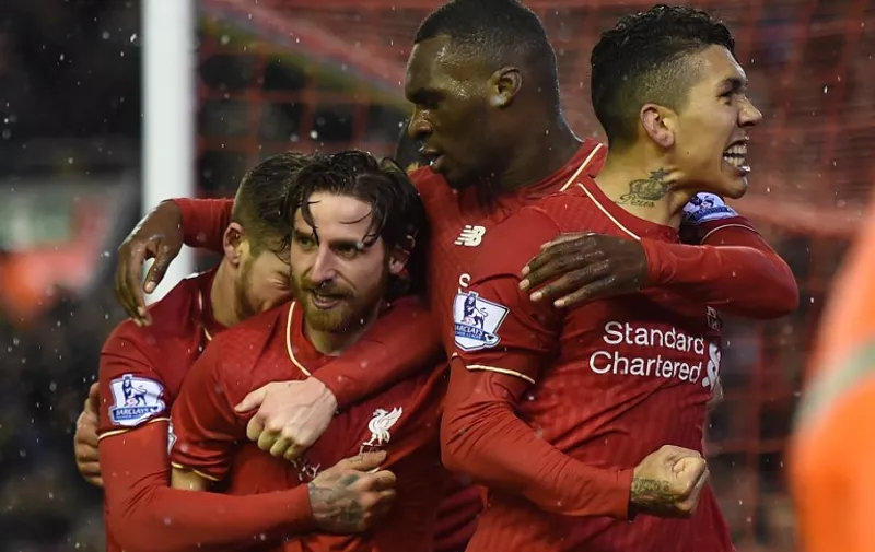 Liverpool's Welsh midfielder Joe Allen (2L) celebrates with teammates after scoring during the English Premier League football match between Liverpool and Arsenal at Anfield stadium in Liverpool, north-west England on January 13, 2016.
AFP PHOTO / PAUL ELLIS
RESTRICTED TO EDITORIAL USE. NO USE WITH UNAUTHORIZED AUDIO, VIDEO, DATA, FIXTURE LISTS, CLUB/LEAGUE LOGOS OR 'LIVE' SERVICES. ONLINE IN-MATCH USE LIMITED TO 75 IMAGES, NO VIDEO EMULATION. NO USE IN BETTING, GAMES OR SINGLE CLUB/LEAGUE/PLAYER PUBLICATIONS. / AFP / PAUL ELLIS