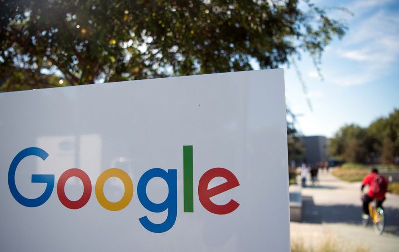 (FILES) In this file photo taken on November 4, 2016 a man rides a bike past a Google sign and logo at the Googleplex in Menlo Park, California. - Google on November 25, 2019 fired four employees on the grounds they had violated data security policies, but the tech titan was accused of persecuting them for trying to unionize staff. The dismissals of the quartet -- dubbed the "Thanksgiving Four" on social media -- deepened staff-management tensions at a company once seen as a paradigm of Silicon Valley freedoms but now embroiled in numerous controversies. (Photo by JOSH EDELSON / AFP)
