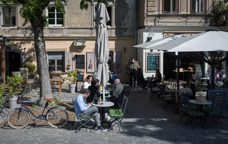 People sit at a caffe terrace in Ljubljana, on May 4, 2020, on the first day of the lockdown ease amid the Covid-19 pandemic caused by the novel coronavirus. - Bars and hairdressers are allowed to reopen from May 4, 2020 in Slovenia under strict hygienic and distancing rules. (Photo by Jure Makovec / AFP)