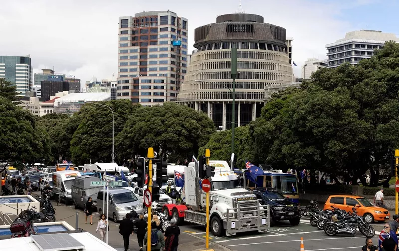 Trucks and other vehicles sit parked on the streets outside the parliament building (C) in Wellington on February 8, 2022, during a demonstration against Covid restrictions, inspired by a similar demonstration in Canada. (Photo by Marty MELVILLE / AFP)
