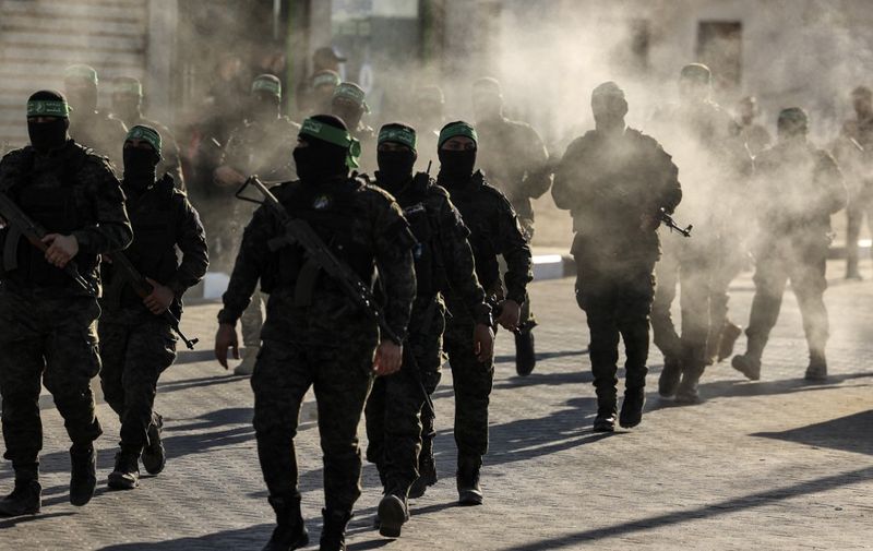 Masked members of the al-Qassam Brigades, the military wing of Hamas, march during a rally in Gaza City on July 20, 2022. (Photo by Mahmud HAMS / AFP)