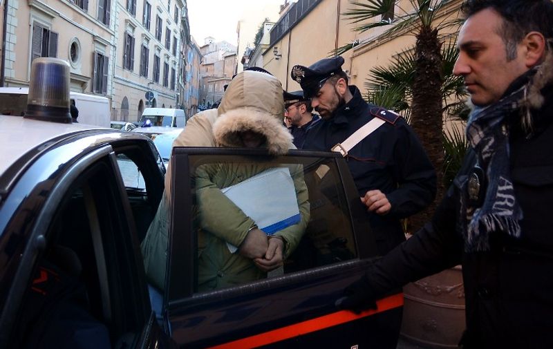 A man is taken into the Carabinieri headquarters on February 10, 2015 in Rome after being arrested during a police operation against Roman crime organisation. Italian police on Tuesday arrested 61 people after a probe established the existence of a criminal organisation linked to the Neapolitan Camorra mafia operating in the southeast of the capital. Police seized 10 million euros in assets in the operation, which they said had dismantled the organisation.  AFP PHOTO / FILIPPO MONTEFORTE