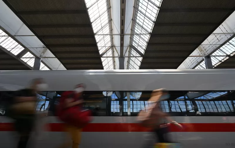 Passengers walk in front of a high speed train ICE in the central station in Munich, southern Germany, during a wage strike by German train drivers on September 4, 2021. - Germany's train drivers union GDL launched fresh strikes affecting passengers and freight traffic that will last longer than previous stoppages, as a wage dispute with managers escalates. (Photo by Christof STACHE / AFP)