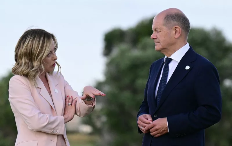 Italy's Prime Minister Giorgia Meloni chats with German Chancellor Olaf Scholz during a flags ceremony at Borgo Egnazia Golf Club San Domenico during the G7 Summit hosted by Italy in Apulia region, on June 13, 2024 in Savelletri. Leaders of the G7 wealthy nations gather in southern Italy this week against the backdrop of global and political turmoil, with boosting support for Ukraine top of the agenda. (Photo by Tiziana FABI / AFP)