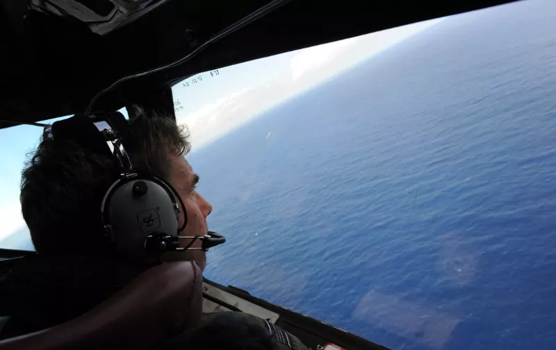 In this photo taken from a Royal New Zealand Airforce (RNZAF) P-3K2-Orion aircraft, co-pilot and Squadron Leader Brett McKenzie helps to look for objects during the search for missing Malaysia Airlines flight MH370, off Perth on April 13, 2014.  AFP PHOTO / POOL / Greg WOOD