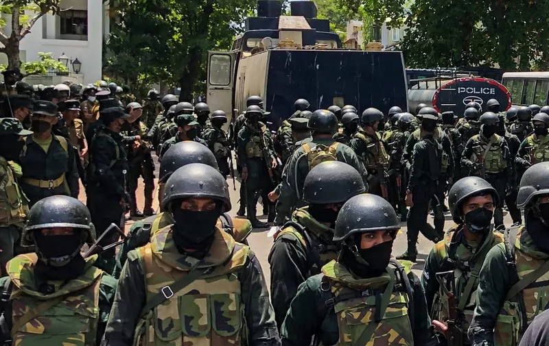 Army soldiers stand guard during an anti-government protest by demonstrators outside the office of Sri Lanka's prime minister in Colombo on July 13, 2022. - Sri Lankan police fire tear gas to hold back thousands of demonstrators mobbing the premier's office in Colombo on July 13, AFP reporters at the scene saw. (Photo by AFP)
