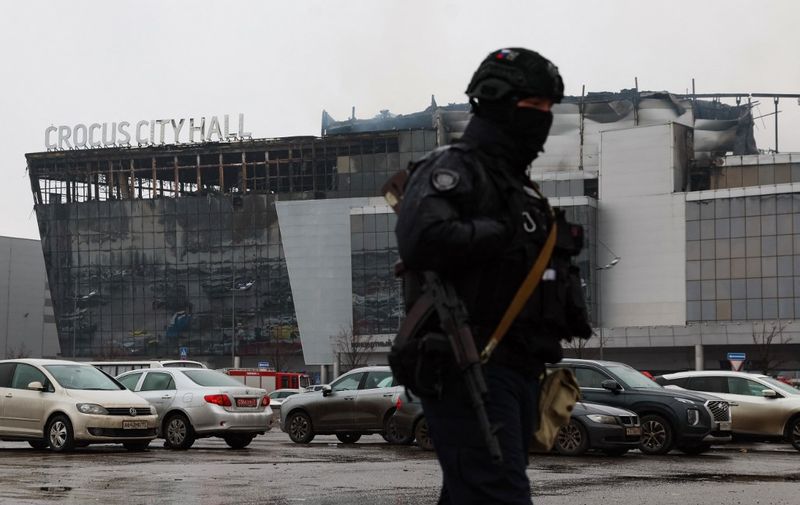 A law enforcement officer patrols the scene of the gun attack at the Crocus City Hall concert hall in Krasnogorsk, outside Moscow, on March 23, 2024. Gunmen who opened fire at a Moscow concert hall killed more than 60 people and wounded over 100 while sparking an inferno, authorities said on March 23, 2024, with the Islamic State group claiming responsibility. (Photo by STRINGER / AFP)