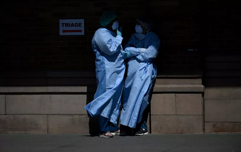 Medical workers take a break outside a special COVID-19 area at Maimonides Medical Center on May 14, 2020 in the Borough Park neighborhood of Brooklyn in New York City. (Photo by Johannes EISELE / AFP)