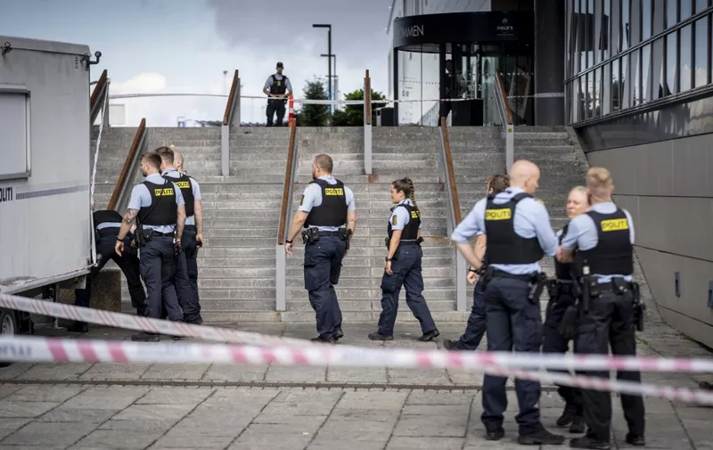 Police stand near the site of the Fields shopping mall, in Copenhagen, on July 4, 2022, one day after where a deadly shooting was perpetrated, leaving three people dead and several others wounded including three in critical condition. Danish police said on July 4, 2022 that the 22-year-old suspect in the shooting that left three dead was known to mental health services and that the victims appeared to have been randomly targeted and there was nothing to indicate it was an act of terror. (Photo by Mads Claus Rasmussen / Ritzau Scanpix / AFP) / Denmark OUT