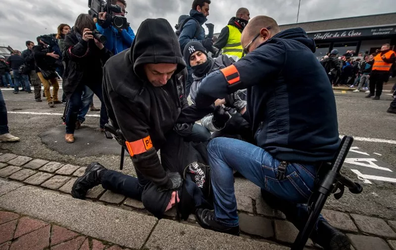 Policemen arrest a supporter of the Pegida movement (Patriotic Europeans Against the Islamisation of the Occident) during a demonstration in Calais, northern France on February 6, 2016. 

Anti-migrant protesters in the French port city of Calais clashed with police as they defied a ban and rallied in support of a Europe-wide initiative by the Islamophobic Pegida movement. / AFP / PHILIPPE HUGUEN