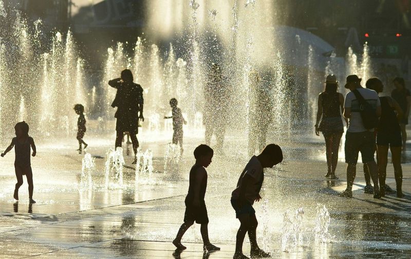 Children play in the water fountains at the Place des Arts in Montreal, Canada on a hot summer day July 3, 2018. (Photo by EVA HAMBACH / AFP)