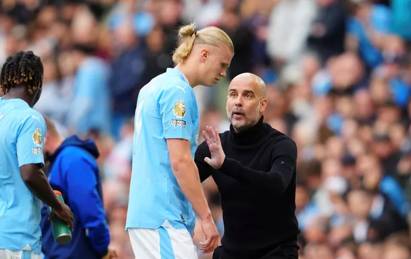 Manchester City's head coach Pep Guardiola speaks to Manchester City's Erling Haaland during the English Premier League soccer match between Manchester City and Nottingham Forest at Etihad stadium in Manchester, England, Saturday, Sept. 23, 2023. (AP Photo/Jon Super)