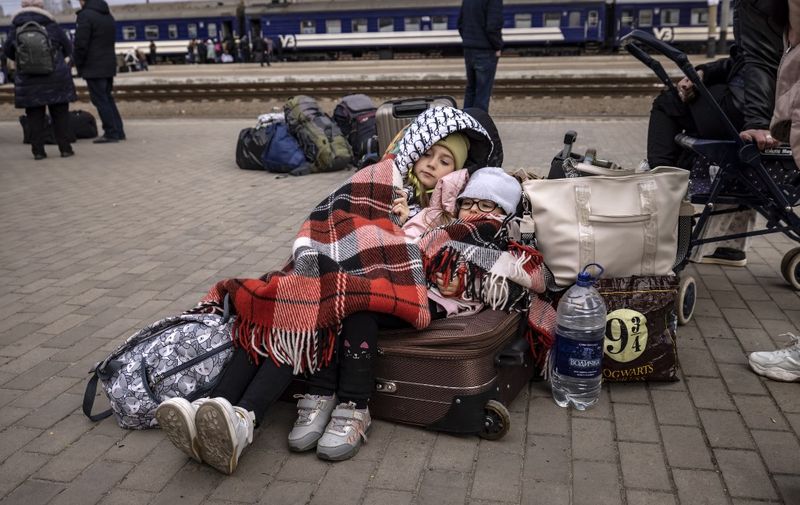 Children lay down on luggages as families wait to board a train at Kramatorsk central station as they flee the eastern city of Kramatorsk, in the Donbass region on April 5, 2022. (Photo by FADEL SENNA / AFP)