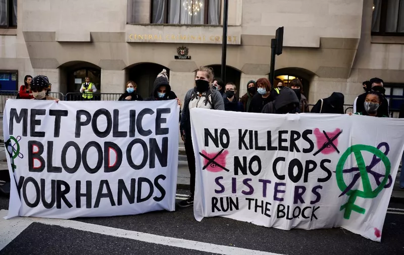 Demonstrators hold banners as they await the sentencing of British police officer Wayne Couzens for the murder of Sarah Everard, outside the Old Bailey court in London on September 29, 2021. - Couzens had pleaded guilty to the murder of the 33-year-old marketing executive whose disappearance sparked outrage and a national debate about women's safety. (Photo by Tolga Akmen / AFP)