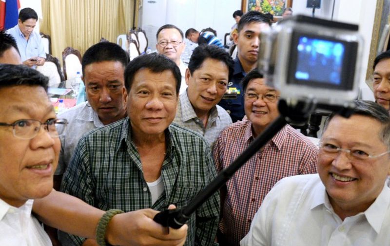 Philippines' President-elect Rodrigo Duterte (C) takes a selfie with Cabinet members during a press conference in the southern Philippine city of Davao on May 31, 2016. XGTY / RESTRICTED TO EDITORIAL USE - MANDATORY CREDIT "AFP PHOTO / KING RODRIGUEZ / DAVAO CITY MAYOR'S OFFICE" - NO MARKETING NO ADVERTISING CAMPAIGNS - DISTRIBUTED AS A SERVICE TO CLIENTS
Philippine president-elect Rodrigo Duterte's war on crime appears to have begun ahead of him taking office, rights activists said May 31, as they voiced concern over a spate of police and vigilante killings. / AFP PHOTO / Davao City mayor's office / KING RODRIGUEZ / RESTRICTED TO EDITORIAL USE - MANDATORY CREDIT "AFP PHOTO / KING RODRIGUEZ / DAVAO CITY MAYOR'S OFFICE" - NO MARKETING NO ADVERTISING CAMPAIGNS - DISTRIBUTED AS A SERVICE TO CLIENTS