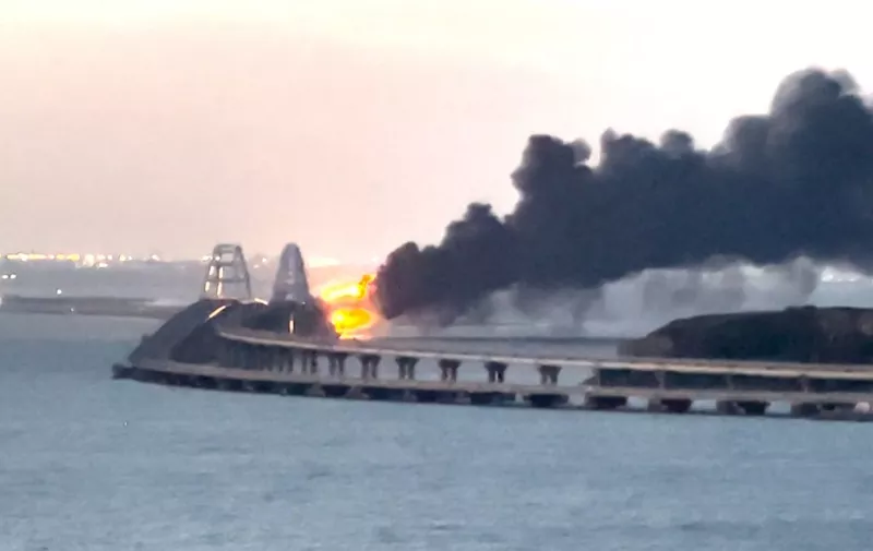 This video grab taken and released on October 8, 2022 shows thick black smoke rising from a fire on the Kerch bridge that links Crimea to Russia. - Moscow announced on October 8, 2022 that a truck exploded igniting a huge fire and damaging the key Kerch bridge -- built as Russia's sole land link with annexed Crimea -- and vowed to find the perpetrators, without immediately blaming Ukraine. (Photo by AFP)