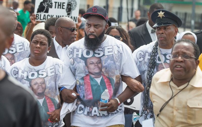 FERGUSON, MO - AUGUST 09: Michael Brown Sr. (C) leads a march from the location where his son Michael Brown Jr. was shot and killed following a memorial service marking the anniversary his death on August 9, 2015 in Ferguson, Missouri. Brown Jr, was shot and killed by a Ferguson police officer on August 9, 2014. His death sparked months of sometimes violent protests in Ferguson and drew nationwide focus on police treatment of black offenders.   Scott Olson/Getty Images/AFP