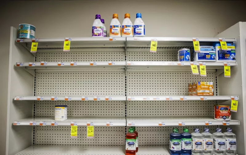 Shelves normally meant for baby formula sit nearly empty at a store in downtown Washington, DC, on May 22, 2022. - A US military plane bringing several tons of much-needed baby formula from Germany landed on May 22, 2022, at an airport in Indiana as authorities scramble to address a critical shortage. (Photo by Samuel Corum / AFP)