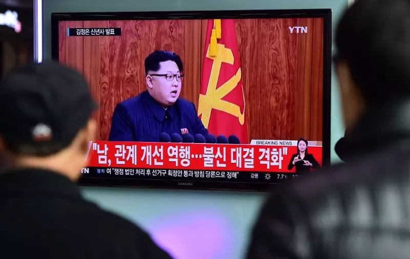 Commuters walk past a television screen showing a broadcast of North Korean leader Kim Jong-Un's New Year speech, at a railroad station in Seoul on January 1, 2016. North Korean leader Kim Jong-Un said raising living standards was his number one priority in an annual New Year's address on January 1 that avoided any explicit reference to the country's nuclear weapons programme.  AFP PHOTO / JUNG YEON-JE / AFP / JUNG YEON-JE