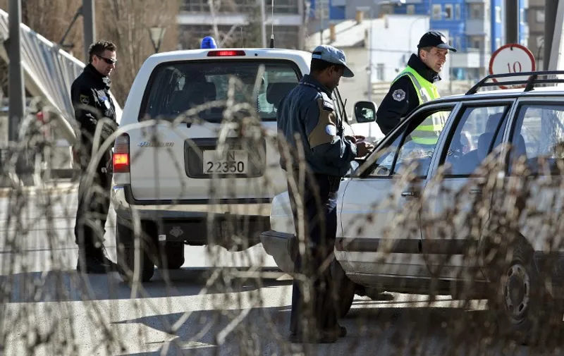 Kosovo and UN mission in Kosovo (UNMIK) police patrol and control a car in a bridge in the ethnically divided Kosovo town of Mitrovica on February 14, 2008. Serbia and Russia stepped up warnings on Thursday that they would not accept the independence of Kosovo ahead of a UN Security Council emergency meeting on the breakaway province. AFP PHOTO/ROBERT ATANASOVSKI