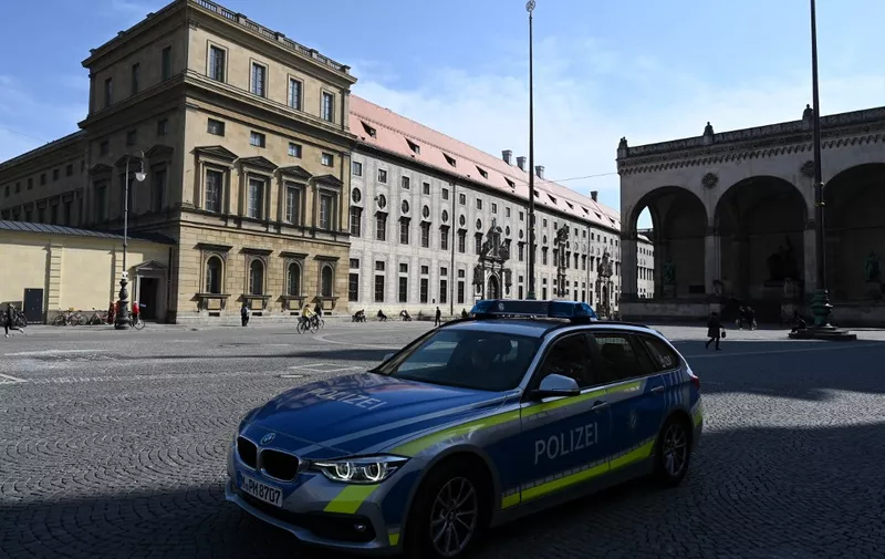 A police car passes Odeonsplatz in the city of Munich, southern Germany, on March 27, 2020, as public life in Bavaria has been limited due to the coronavirus COVID-19. (Photo by Christof STACHE / AFP)