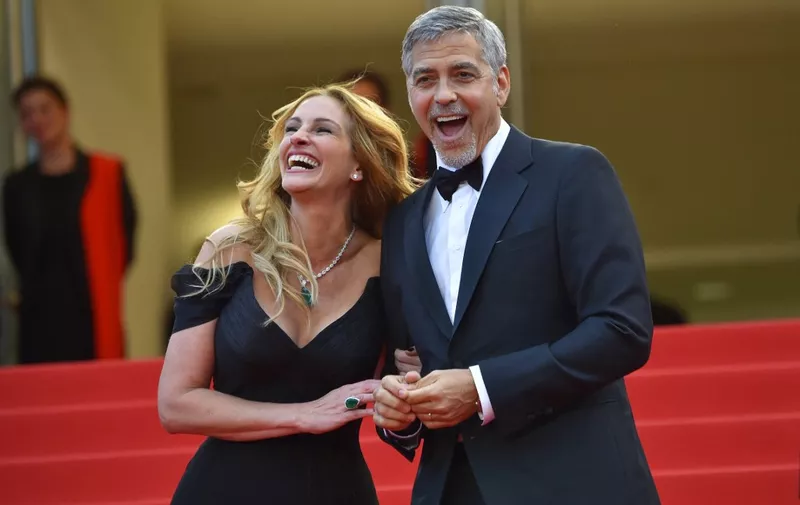 US actress Julia Roberts laughs on May 12, 2016 with US actor George Clooney as they arrive for the screening of the film "Money Monster" at the 69th Cannes Film Festival in Cannes, southern France. (Photo by LOIC VENANCE / AFP)