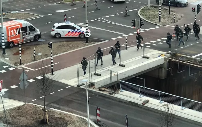 In this handout picture from the twitter account of @michadrost, special police forces patrol in Utrecht after a shooting near the 24 Oktoberplace, on March 18, 2019. - Three people were killed and nine injured in a shooting in the Dutch city of Utrecht, the mayor said today, adding that authorities were working on the basis of it being a terrorist attack. Dutch police released a picture of Turkish-born Gokmen Tanis they are hunting over a shooting on a tram in Utrecht today. (Photo by @michadrost / various sources / AFP) / RESTRICTED TO EDITORIAL USE - MANDATORY CREDIT "AFP PHOTO / Twitter / @michadrost" - NO MARKETING NO ADVERTISING CAMPAIGNS - DISTRIBUTED AS A SERVICE TO CLIENTS --- NO ARCHIVE ---