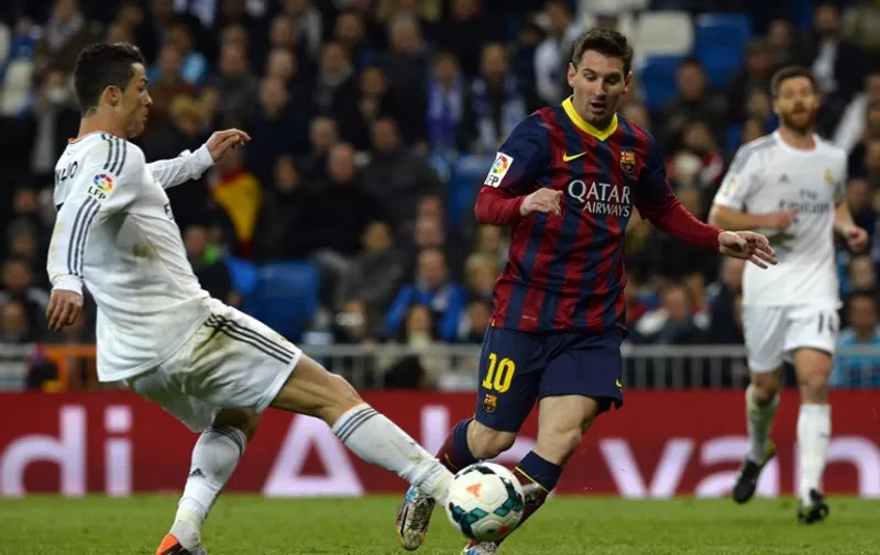 Barcelona's Argentinian forward Lionel Messi (R) vies with Real Madrid's Portuguese forward Cristiano Ronaldo during the Spanish league "Clasico" football match Real Madrid CF vs FC Barcelona at the Santiago Bernabeu stadium in Madrid on March 23, 2014. Barcelona won 4-3.   AFP PHOTO/ GERARD JULIEN / AFP / GERARD JULIEN