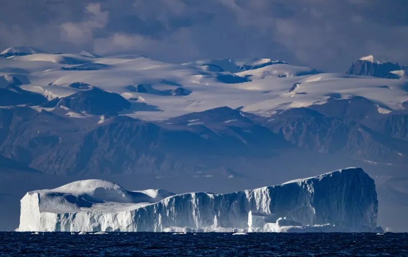 This photograph taken on August 16, 2023, shows an iceberg, approximately a few hundred metres long, drifting along the Scoresby Sound Fjord, in Eastern Greenland. The 2023 United Nations Climate Change Conference COP28 will be held from November 30 to December 12, 2023, in Dubai. (Photo by Olivier MORIN / AFP)