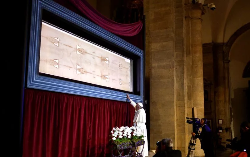 Pope Francis touches the holy Shroud, believed by some Christians to be the burial shroud of Jesus of Nazareth, on June 21, 2015  in Turin's cathedral. AFP PHOTO / ALBERTO PIZZOLI
