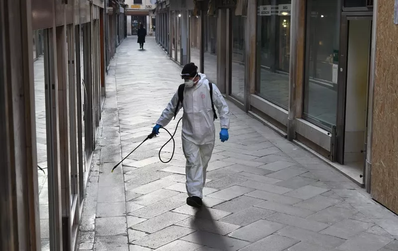 An employee of the municipal company Veritas sprays disinfectant in public areas in Venice on March 11, 2020, as part of precautionary measures against the spread of the new coronavirus COVID-19, a day after Italy imposed unprecedented national restrictions on its 60 million people Tuesday to control the deadly COVID-19 coronavirus. (Photo by MARCO SABADIN / AFP)