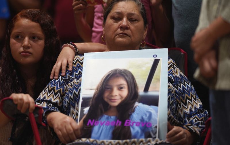 A woman holds a photo of Nevaeh Bravo, who was killed in the mass shooting, during a vigil for the victims of the mass shooting at Robb Elementary School in Uvalde, Texas on May 25, 2022. - The tight-knit Latino community of Uvalde was wracked with grief Wednesday after a teen in body armor marched into the school and killed 19 children and two teachers, in the latest spasm of deadly gun violence in the US. (Photo by allison dinner / AFP)
