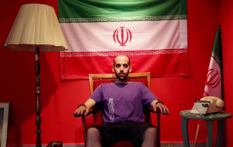 Israeli artist Matan Pinkas sits in the "Iranian Embassy in Jerusalem," a cultural project in the works by the Jerusalem art collective Hamabul.