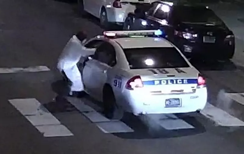 This video still image obtained January 8, 2016 courtesy of the Philadelphia Police Department, shows a shooting suspect and police car on January 7, 2016 in Philadelphia, PA. A self-professed sympathizer of the Islamic State extremist group shot and seriously wounded a police officer in Philadelphia, opening fire multiple times at point blank range with a stolen weapon, police said Friday.The assassination attempt comes amid heightened security in the United States following last month's assault by a radicalized Muslim couple in California that killed 14 people and the November terror attacks in Paris. Police officer Jesse Hartnett, 33, was shot three times in his left arm as he sat in his patrol car late Thursday in the northeastern city. Police said they are astonished he survived. AFP PHOTO/PHILADELPHIA POLICE DEPARTMENT/HANDOUT = RESTRICTED TO EDITORIAL USE - MANDATORY CREDIT "AFP PHOTO /PHILADELPHIA POLICE DEPARTMENT " - NO MARKETING NO ADVERTISING CAMPAIGNS - DISTRIBUTED AS A SERVICE TO CLIENTS = / AFP / PHILADELPHIA POLICE DEPARTMENT / HO