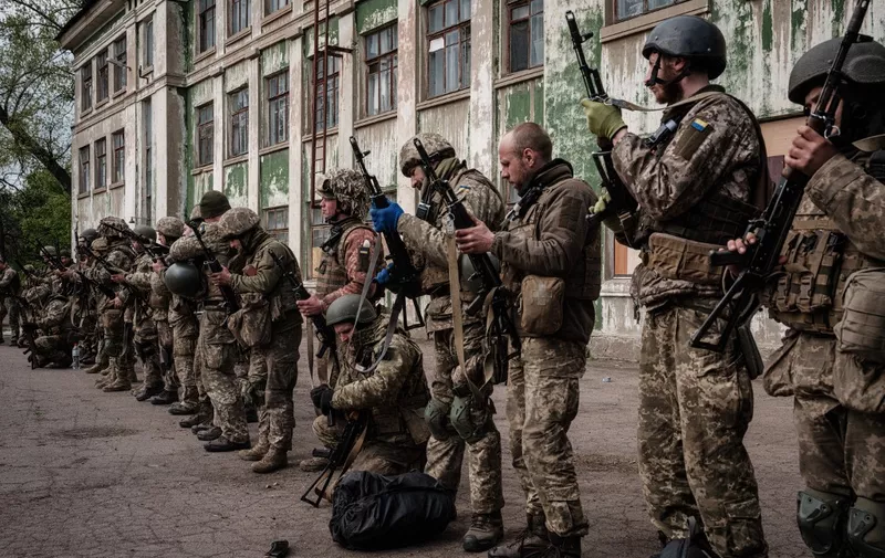 Ukrainian soldiers unload their guns as they arrive at an abandoned building to rest and receive medical treatment after fighting on the front line for two months near Kramatorsk, eastern Ukraine on April 30, 2022. - Russia invaded Ukraine on February 24, 2022. (Photo by Yasuyoshi CHIBA / AFP)