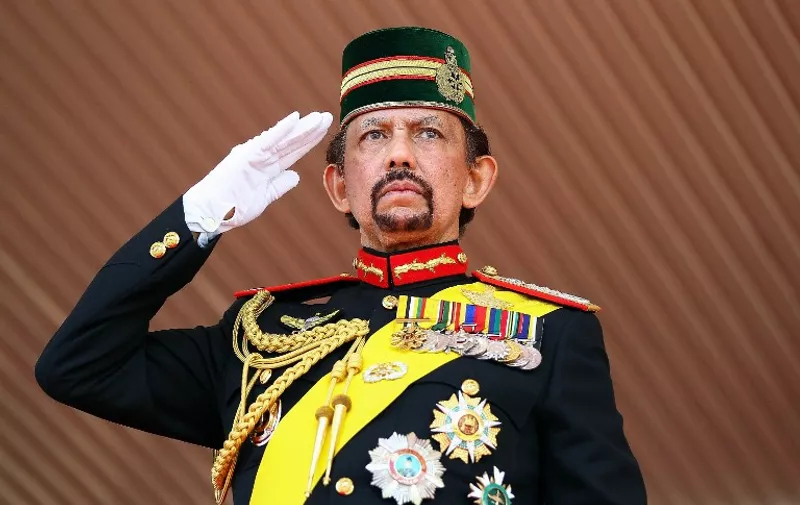 Brunei's Sultan Hassanal Bolkiah salutes during a ceremonial guard of honour to mark his 68th birthday celebrations in Bandar Seri Begawan on August 14, 2014. The monarch turned 68 on July 15, but the celebrations were postponed due to the holy month of Ramadan. The sultan is one of the world's longest-reigning monarchs.  AFP PHOTO / AFP / STR