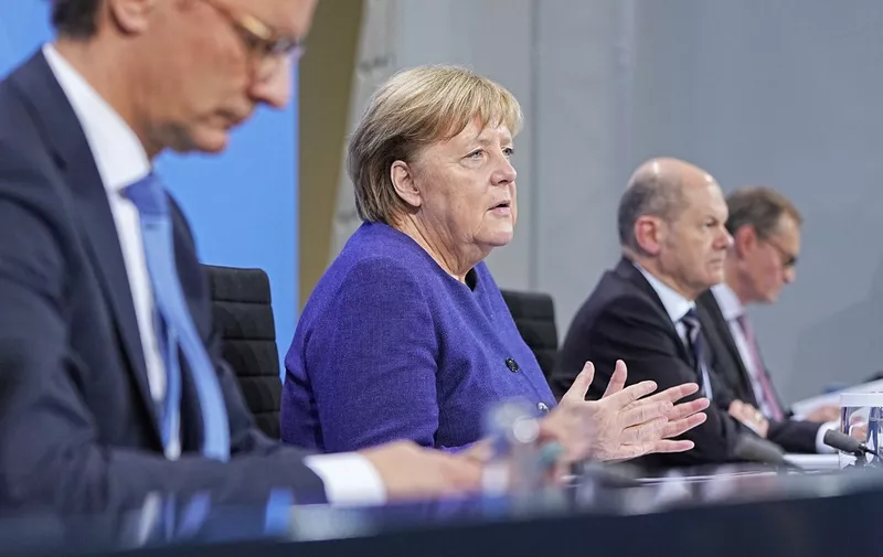 (FILES) In this file photo taken on November 18, 2021 German Chancellor Angela Merkel (2nd L), North Rhine-Westphalia's State Premier Hendrik Wuest (L), German Finance Minister and candidate for Chancellor Olaf Scholz (2nd R) and Berlin Mayor Michael Mueller (R) address a press conference following a video meeting to discuss the ongoing Covid-19 pandemic with the heads of government of Germany's federal states at the Chancellery in Berlin. - Chancellor Angela Merkel and her successor in waiting Olaf Scholz will hold talks on November 30, 2021 with leaders of Germany's 16 states on toughening restrictions to halt a surge of coronavirus infections, sources told AFP. (Photo by Michael Kappeler / POOL / AFP)