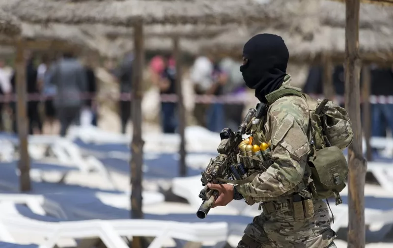 A masked Tunisian soldier stands guard on the beach at the Riu Imperial Marhaba Hotel in Port el Kantaoui, on the outskirts of Sousse south of the capital Tunis, on June 29, 2015 where a deadly attack took place the previous week. Tunisia said it had made its first arrests after a beach massacre that killed 38 people, as European officials paid tribute to victims of the country's worst jihadist attack. AFP PHOTO / KENZO TRIBOUILLARD