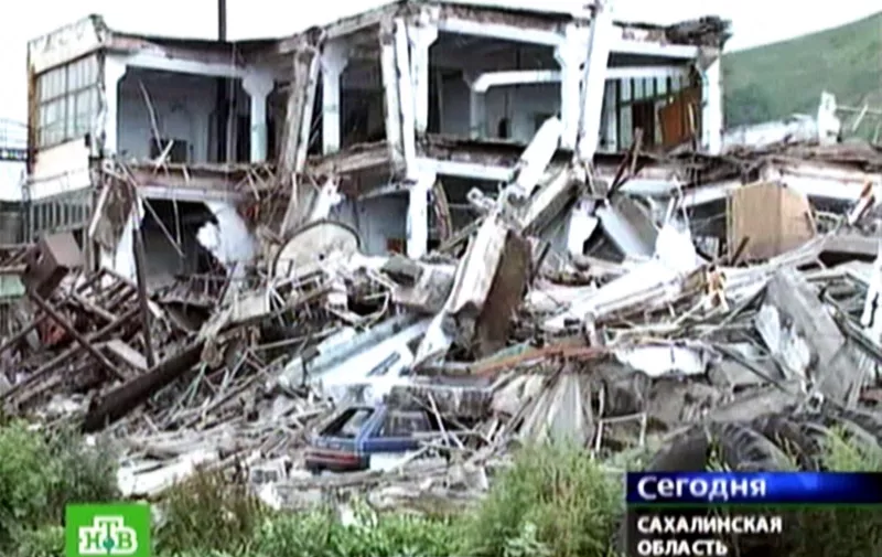 A Russian NTV channel TV grab shows the remains of an apartment building destroyed by an earthquake on Sakhalin Island in Russia's Far East, 02 August 2007. Two earthquakes hit the island of Sakhalin in Russia's far east killing at least two people and triggering small tsunami waves on Japan's coast, officials said. Russian authorities declared a state of emergency in the western part of the island as aftershocks continued to shake the region, causing extensive damage to buildings, Russia's emergency situations ministry said. AFP PHOTO / NTV (Photo by NTV / NTV / AFP)