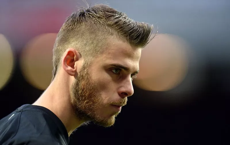 (FILES) A picture taken on December 14, 2014 shows Manchester United's Spanish goalkeeper David de Gea leaving the pitch at the final whistle in the English Premier League football match between Manchester United and Liverpool at Old Trafford in Manchester, north west England. Spanish international goalkeeper David de Gea's proposed move to Real Madrid was halted on on August 31, 2015 as the documentation needed to formalise the transfer from Manchester United wasn't completed in time according to reports.
   AFP PHOTO/ OLI SCARFF

RESTRICTED TO EDITORIAL USE. No use with unauthorized audio, video, data, fixture lists, club/league logos or live services. Online in-match use limited to 45 images, no video emulation. No use in betting, games or single club/league/player publications.