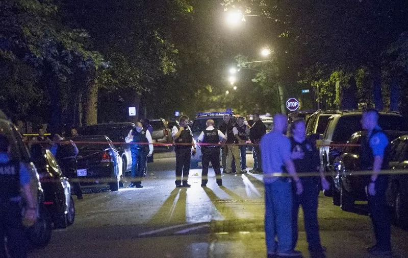 CHICAGO, IL - SEPTEMBER 28: Police officers investigate a shooting scene where 5 people were reported to have been shot, including an 11-month-old infant, on September 28, 2015 in Chicago, Illinois. Chicago, like many major cities in the United States, has experienced a surge in shootings this year.   Scott Olson/Getty Images/AFP