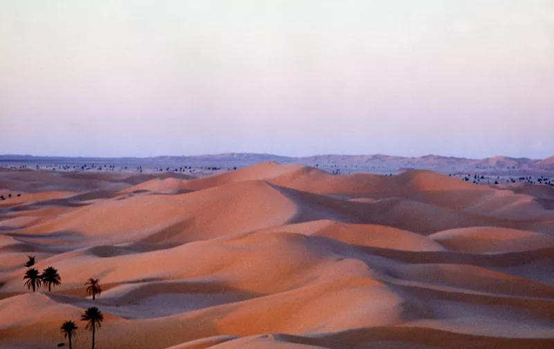 Vue prise en octobre 1978 en Algérie, d'un coucher de soleil sur les dunes de l'Erg oriental dans la région d'El Oued à l'est du Sahara.