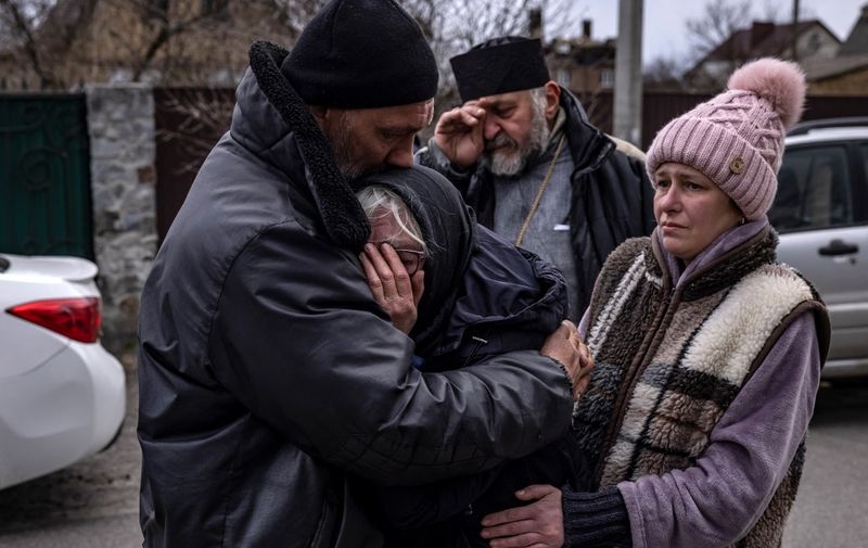 TOPSHOT - Relatives of a civilian man exhumed from his yard react in Gostomel village, Kyiv region on April 12, 2022. (Photo by FADEL SENNA / AFP)