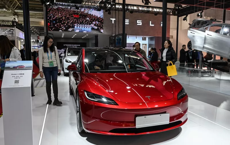 (FILES) People try Tesla's electric vehicle Model 3 at its booth during the China International Supply Chain Expo (CISCE) in Beijing on December 1, 2023. Tesla is recalling more than 1.6 million electric vehicles in China, the country's market regulator said on January 5, 2024, owing to software issues that could pose safety risks while driving. (Photo by JADE GAO / AFP)