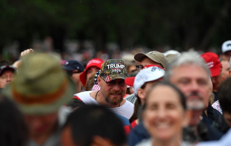 A man wearing a "Trump 2020" cap looks on as people gather on the National Mall ahead of the "Salute to America" Fourth of July event with US President Donald Trump at the Lincoln Memorial in Washington, DC, July 4, 2019. (Photo by Nicholas Kamm / AFP)