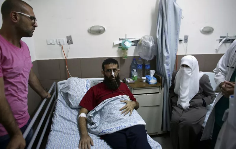 Palestinian Khader Adnan, who staged a 56-day hunger strike while being detained for a year without charge by Israeli authorities and who Israel says is a member of the Islamic Jihad, lies on a bed as he is treated at the Makassed hospital in East Jerusalem on July 15, 2015. The bespectacled 37-year-old was released before dawn on July 12, 2015 after his jail protest against a controversial procedure allowing indefinite detention without charge. AFP PHOTO / AHMAD GHARABLI (Photo by Ahmad GHARABLI / AFP)