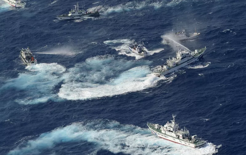 A Japan Coast Guard vessel (R) sprays water against Taiwanese fishing boats, while a Taiwanese coast guard ship (L) also sprays water in the East China Sea near Senkaku islands as known in Japanese or Diaoyu Islands in Chinese on September 25, 2012.  Coastguard vessels from Japan and Taiwan duelled with water cannon after dozens of Taiwanese boats escorted by patrol ships sailed into waters around the Tokyo-controlled islands.  AFP PHOTO / YOMIURI SHIMBUN           JAPAN OUT (Photo by YOMIURI SHIMBUN / YOMIURI SHIMBUN / AFP)